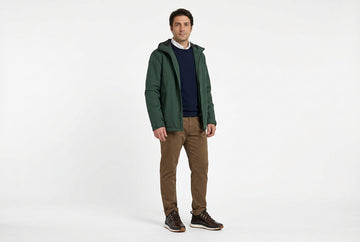 Sneaker Geox uomo indossate con chino fango, maglia merino navy, camicia bianca e giacca impermeabile verde bosco. Outfit 1