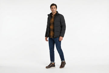 Sneaker Geox uomo indossate con jeans indaco con risvolto, overshirt flanella a quadri marrone e ocra e piumino nero. Outfit 2