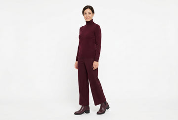 Stivaletti Melluso donna indossati con dolcevita in puro cashmere bordeaux e pantaloni palazzo coordinati in panno morbido. Outfit 2